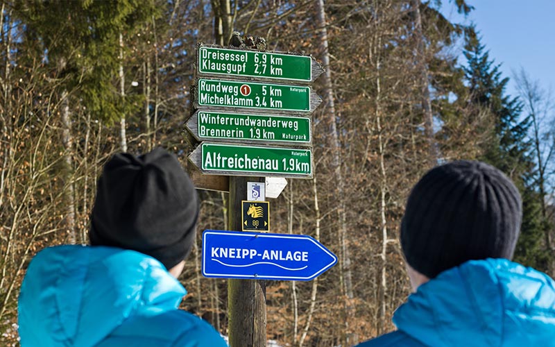 Paar vor Wegweisern und Schildern
